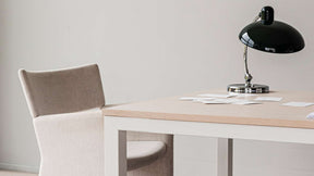 höj och sänkbara matbordet från sidan, med en stol framför, på bordet står en bordsslampa och talkort.